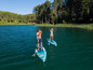 Dvaja ľudia pádlujú na paddleboardoch na jazere.