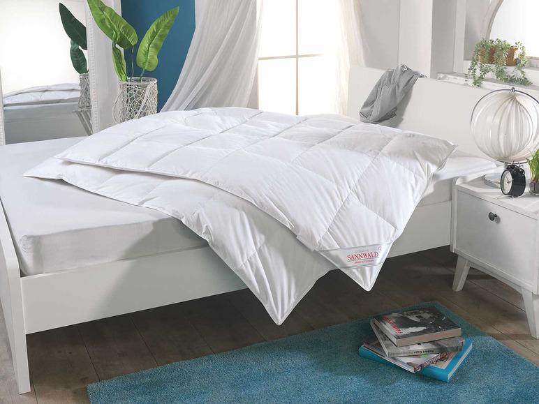 Biela perina značky Sannwald na posteli.