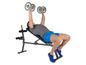 Muž robí bench press s činkami na lavičke.