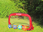 Futbalová bránka Schildkröt Fun Sports s  štyrmi futbalovými loptami na tráve.
