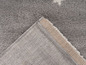 Detail sivého koberca s béžovým okrajom.