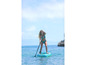 Žena pádluje na nafukovacom paddleboarde v tyrkysovej vode.