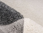 Detail koberca v sivej, bielej a svetlosivej farbe.
