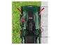 Pohľad zhora na zelenú kosačku na trávu na tráve a dlažbe, s červenými šípkami označujúcimi pohyb.