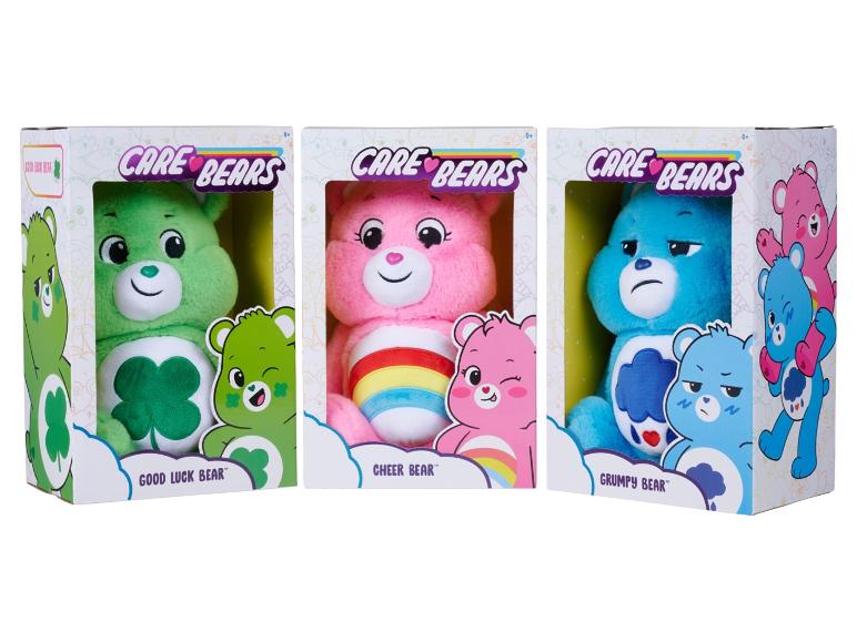 Tri plyšové hračky Care Bears v krabiciach: Good Luck Bear, Cheer Bear a Grumpy Bear.