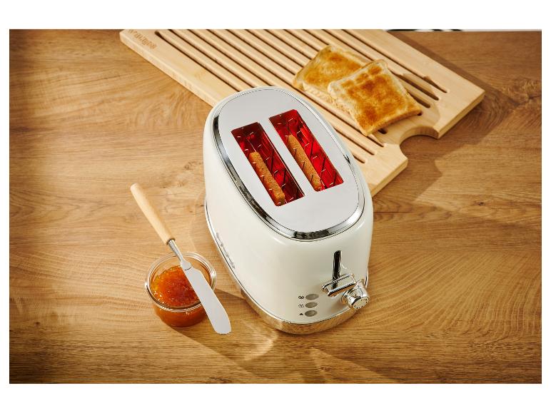 Biely retro toastovač s opečeným chlebom a džemom.