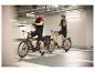 Dvaja cyklisti s elektrickými bicyklami na parkovisku.