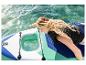 Žena na paddleboarde s priehľadným oknom, ruka sa dotýka vody.