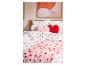 Posteľ s bielou posteľnou bielizňou so vzorom srdiečok a ružovými vankúšmi v tvare srdca
