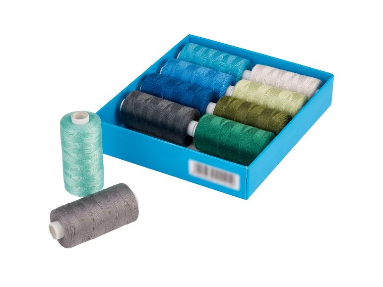 Sada farebných šijacích nití v modrej krabici, s dvoma cievkami vonku.