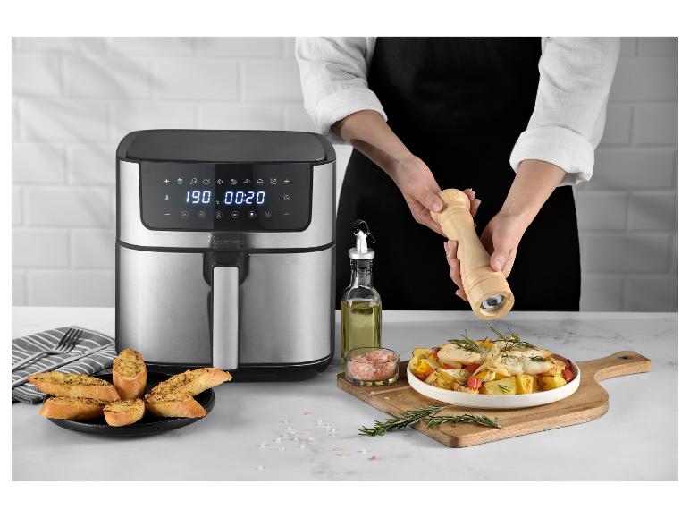 Teplovzdušná fritéza MasterPRO s uvareným jedlom a osobou, ktorá korení.