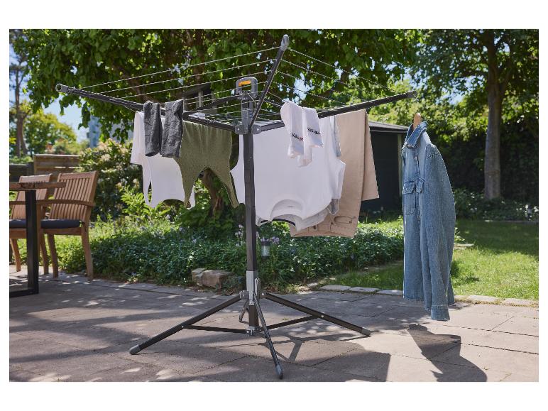 Skladací vonkajší vešiak na bielizeň s oblečením zaveseným na ňom.