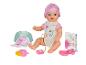 Bábika Baby Born s príslušenstvom, ako je fľaša, cumlík a kniha.
