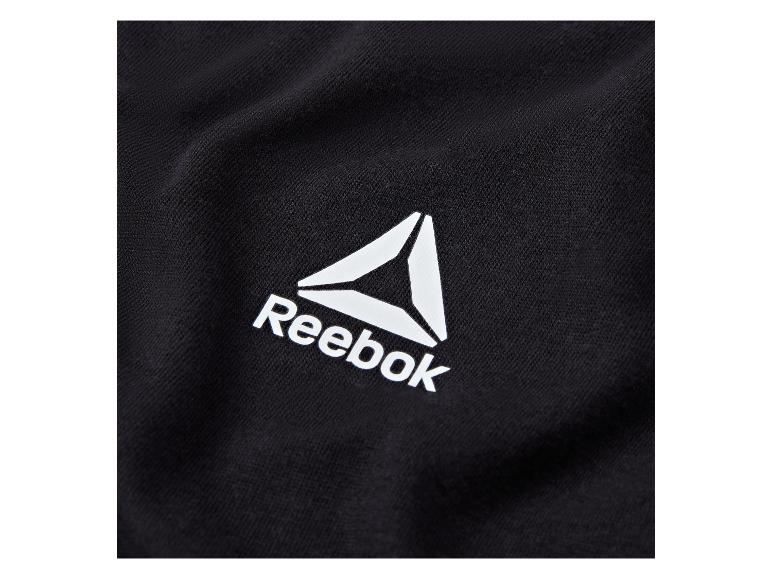 Detail čiernej látky s bielym logom Reebok.