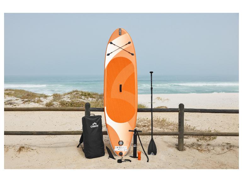 Oranžový a biely SUP board s príslušenstvom na piesočnatej pláži pri mori.