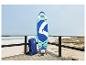 Paddleboard a batoh na drevenej terase pri mori.