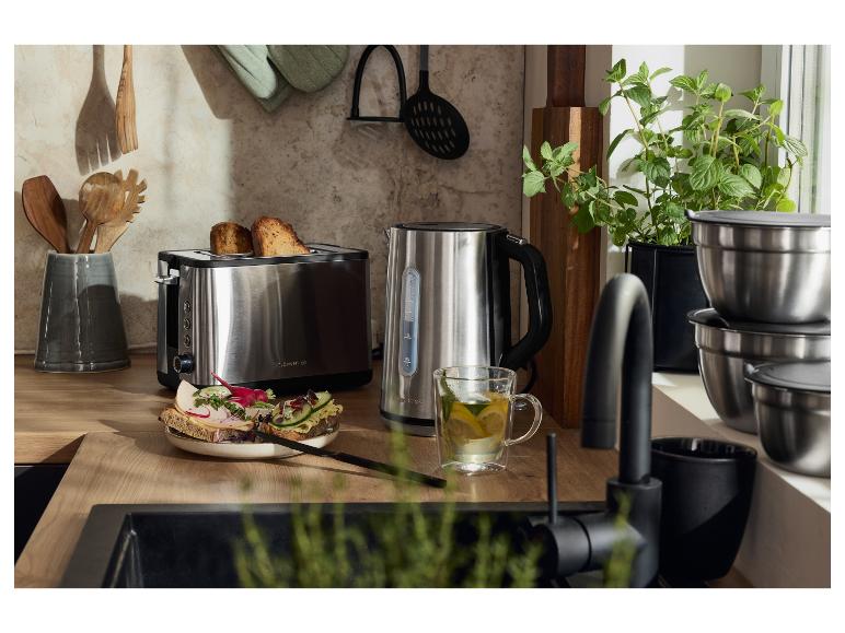 Hriankovač a rýchlovarná kanvica z nehrdzavejúcej ocele na drevenej kuchynskej linke s hriankami a čajom.