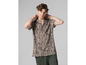 Muž v béžovej košeli s čiernym vzorom.