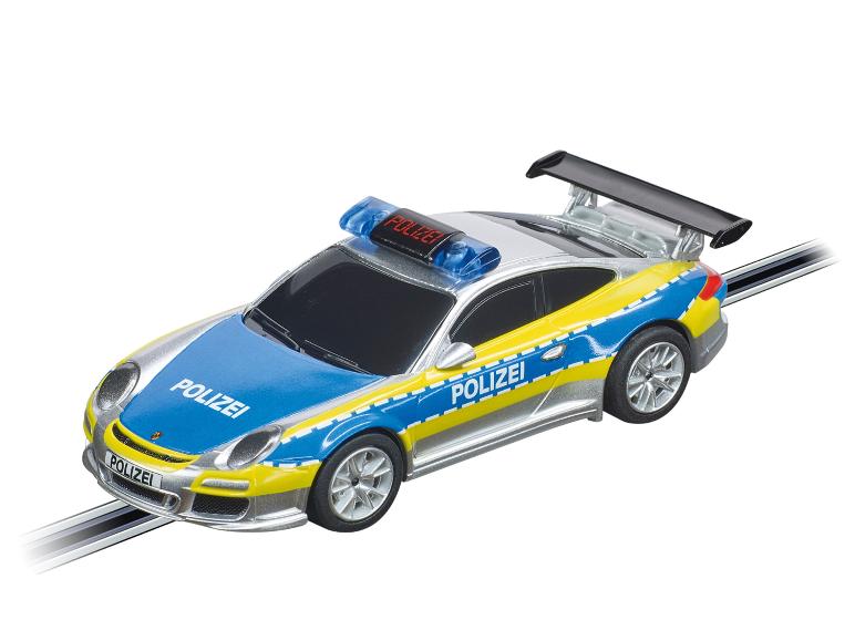 Strieborné policajné auto Porsche na pretekárskej dráhe.
