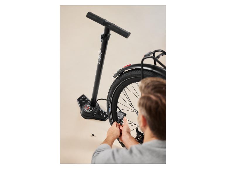 Muž pumpuje pneumatiku bicykla pomocou podlahovej pumpy Crivit.