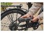 Osoba hustí pneumatiku bicykla prenosnou vzduchovou pumpou Crivit.