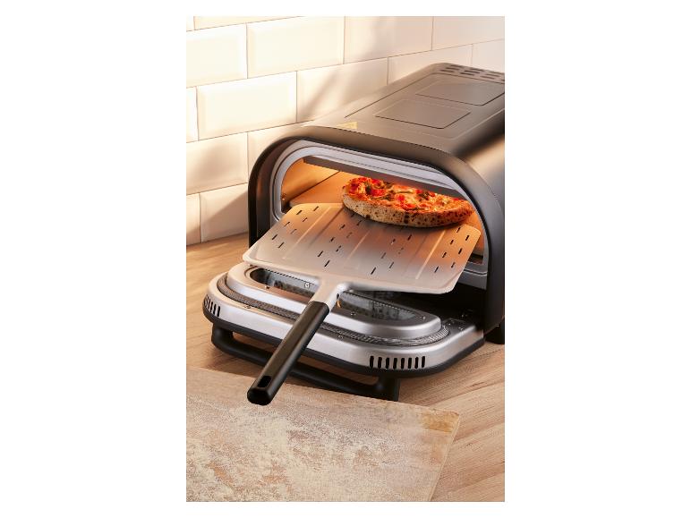 Elektrická pec na pizzu s pizzou, ktorá sa chystá vložiť lopatou.