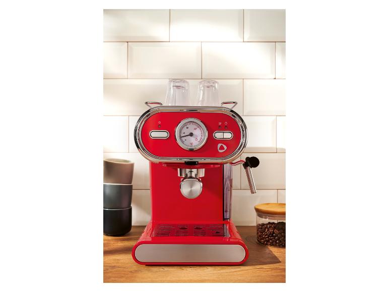 Červený kávovar na kuchynskej linke s šálkami a kávovými zrnami.