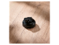 Čierny plastový uzáver fľaše s rukoväťou na drevenom stole.