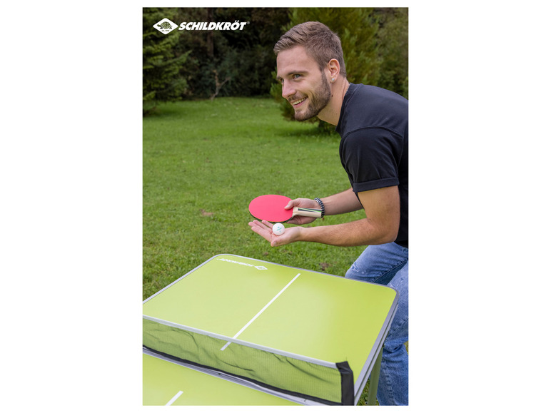 Muž hrá stolný tenis na stole Schildkröt vonku.