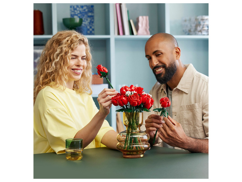 Pár drží LEGO ruže vo váze.