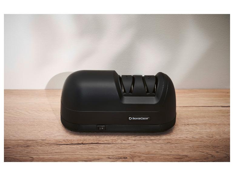 Čierny elektrický brúsič nožov SilverCrest na drevenej doske.