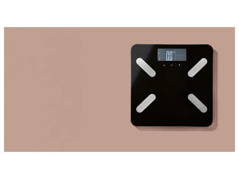 Čierna digitálna váha s displejom zobrazujúcim „0.0 kg“ umiestnená na ružovom povrchu.