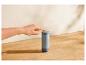 Ruka stláča tlačidlo na sivom termose SilverCrest na drevenej doske.