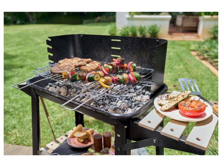 Grilované bravčové rebrá a zeleninové špízy na vonkajšom grile.