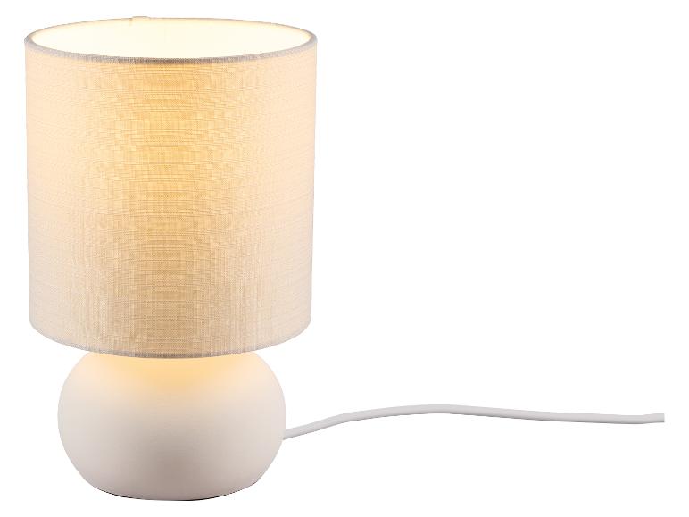 Biela stolová lampa s valcovým textilným tienidlom a guľatou základňou, s káblom.