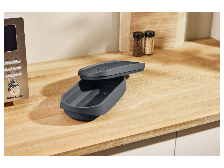 Sivá nádoba SilverCrest na drevenom pulte.