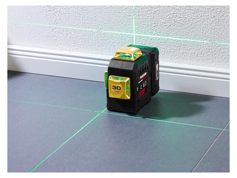 Zelený laserový nivelátor premietajúci horizontálne a vertikálne čiary v miestnosti.