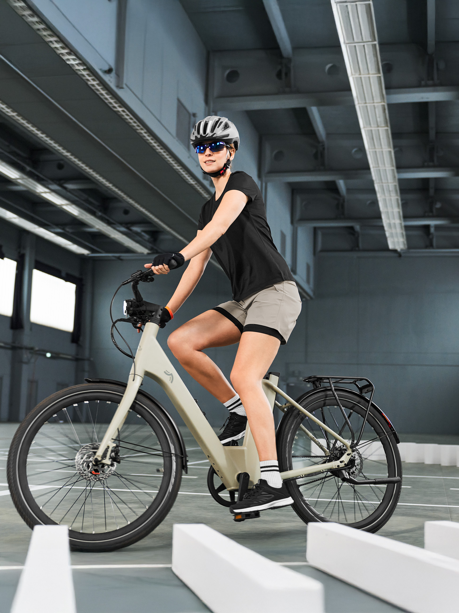 Žena v cyklistickom výstroji na e-bicykli, prechádzajúca vnútornou dráhou.
