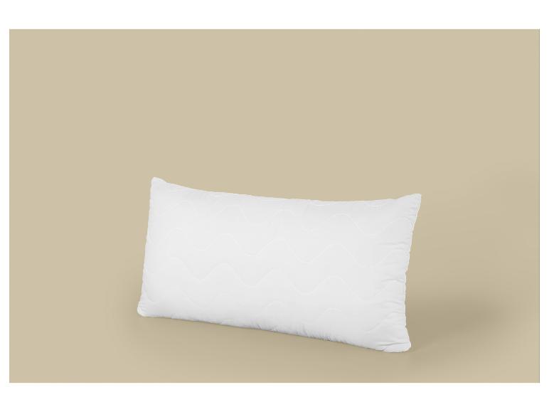 Biely obdĺžnikový vankúš s vlnitým vzorom na béžovom pozadí