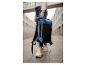 Žena drží tmavomodrý batoh Tambu.