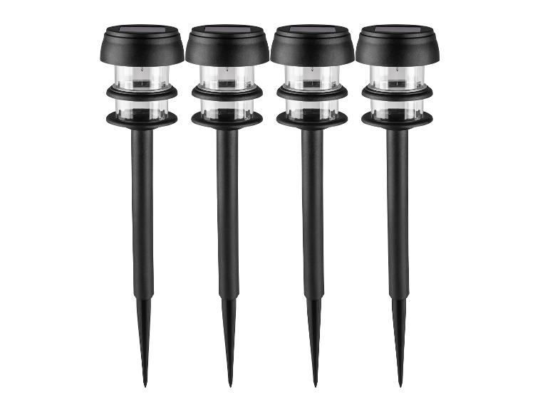 Štyri čierne solárne záhradné svietidlá s priehľadnými plastovými krytmi