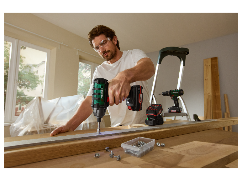 Muž používa akumulátorový skrutkovač Parkside na prácu s drevom.