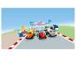 Tri pretekárske autá LEGO Duplo Formula 1 na štartovej čiare s trofejou a mechanickou stanicou.