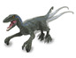 Hračka dinosaura velociraptora v zelenej a modrej farbe na kolieskach.