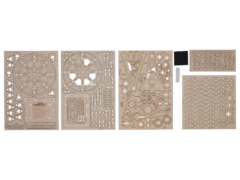 Laserom rezané drevené dosky pre stavebnicu Crelado, s očíslovanými dielmi a návodom.