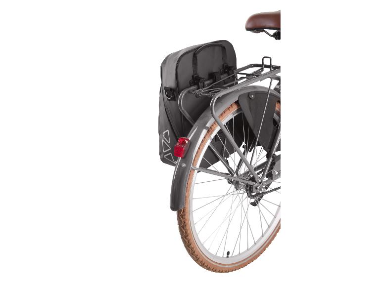 Čierne zadné cyklistické tašky na nosiči bicykla s hnedou pneumatikou.