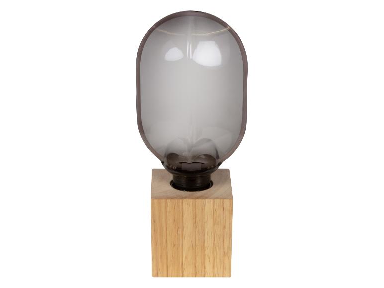 Stolná lampa s dreveným podstavcom a skleneným tienidlom v tvare kapsuly.