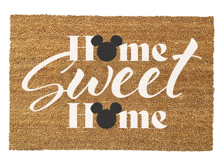 Hnedá rohožka s nápisom „Home Sweet Home“ a čiernymi myšími hlavami.