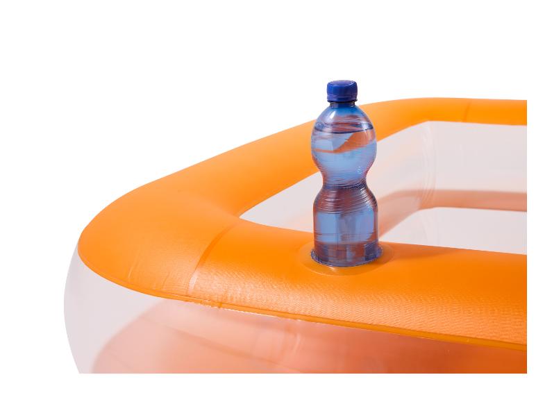 Fľaša vody v oranžovom nafukovacom bazéne