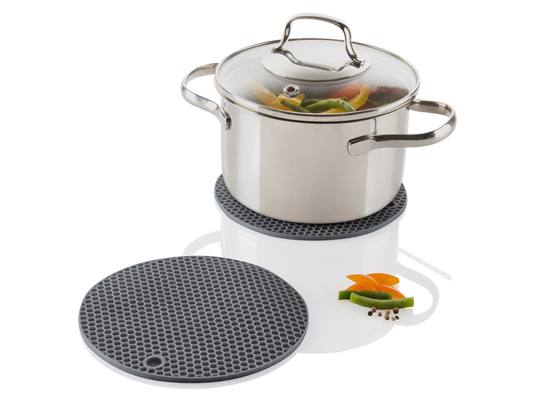 Hrnček s pokrievkou na sivej silikónovej podložke.